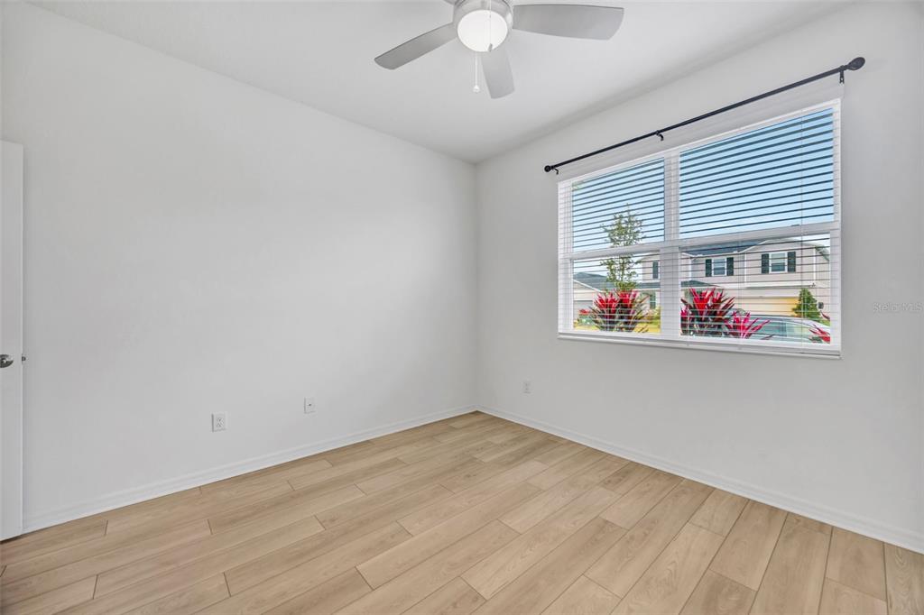 7882 Lennox Loop Wesley Chapel, FL 33544 - Photo 24 of 58 wooden floor in an empty room with a window