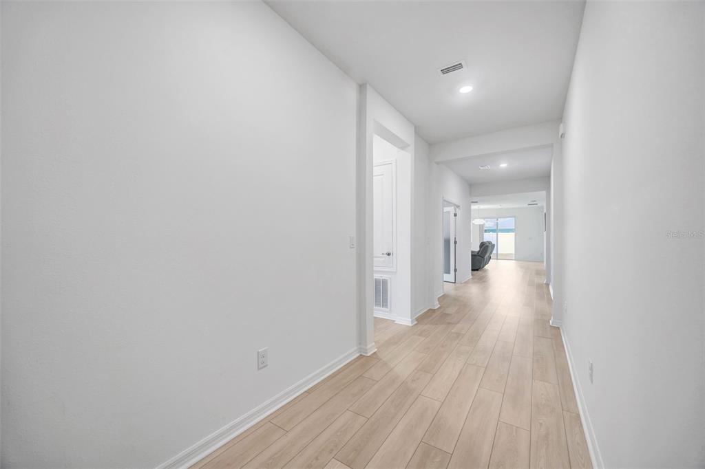 7882 Lennox Loop Wesley Chapel, FL 33544 - Photo 28 of 58 a view of a hallway with wooden floor