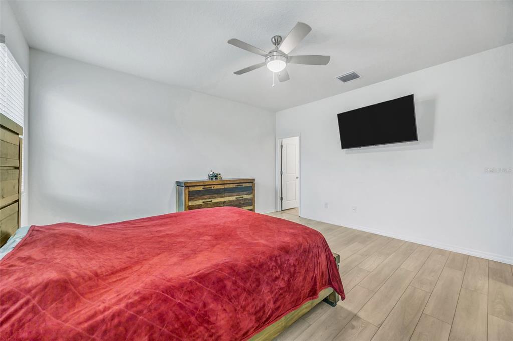 7882 Lennox Loop Wesley Chapel, FL 33544 - Photo 36 of 58 a bed room with a bed a television and a window