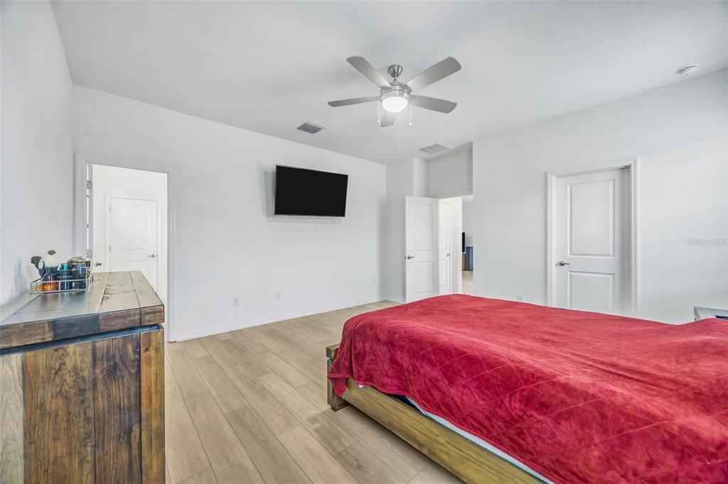 7882 Lennox Loop Wesley Chapel, FL 33544 - Photo 37 of 58 a bedroom with a bed and a flat screen tv