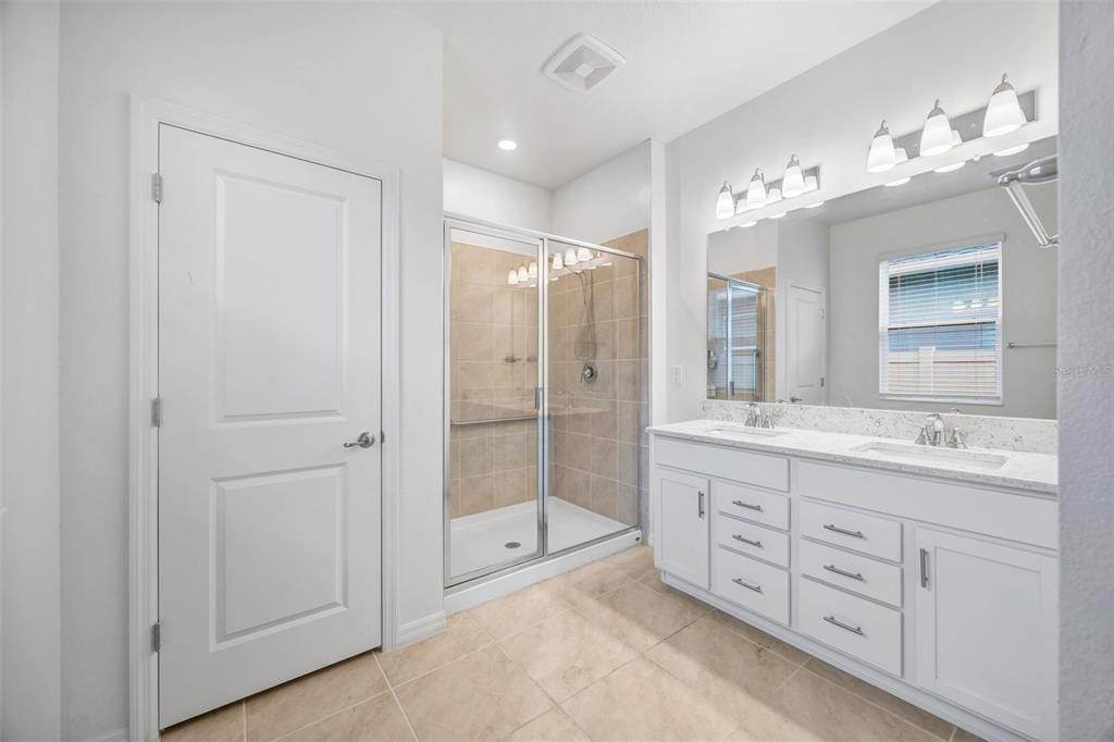 7882 Lennox Loop Wesley Chapel, FL 33544 - Photo 39 of 58 a spacious bathroom with a double vanity sink mirror and double