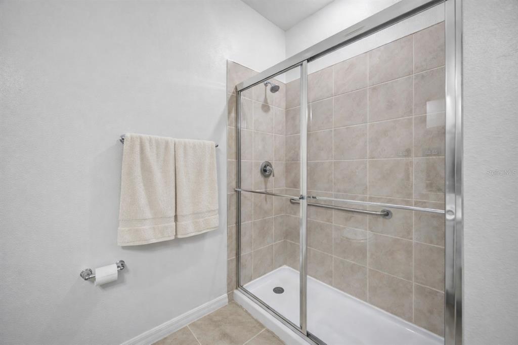 7882 Lennox Loop Wesley Chapel, FL 33544 - Photo 44 of 58 a bathroom with a bathtub and a shower