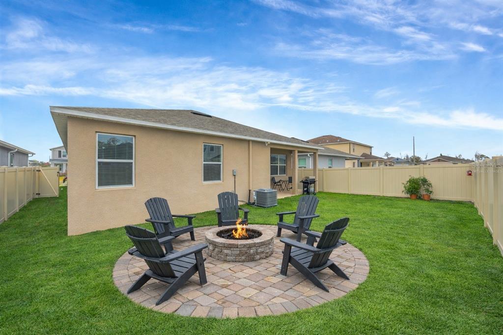 7882 Lennox Loop Wesley Chapel, FL 33544 - Photo 56 of 58 a view of a house with backyard sitting area and garden
