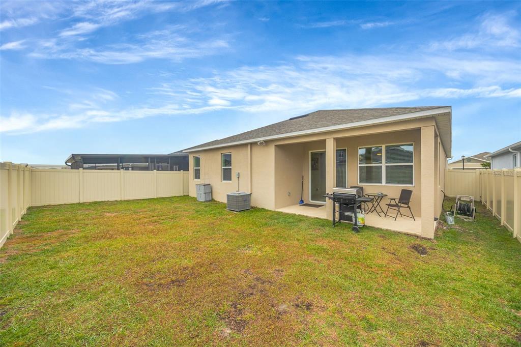 7882 Lennox Loop Wesley Chapel, FL 33544 - Photo 57 of 58 a view of a house with lounge chair and floor to ceiling window