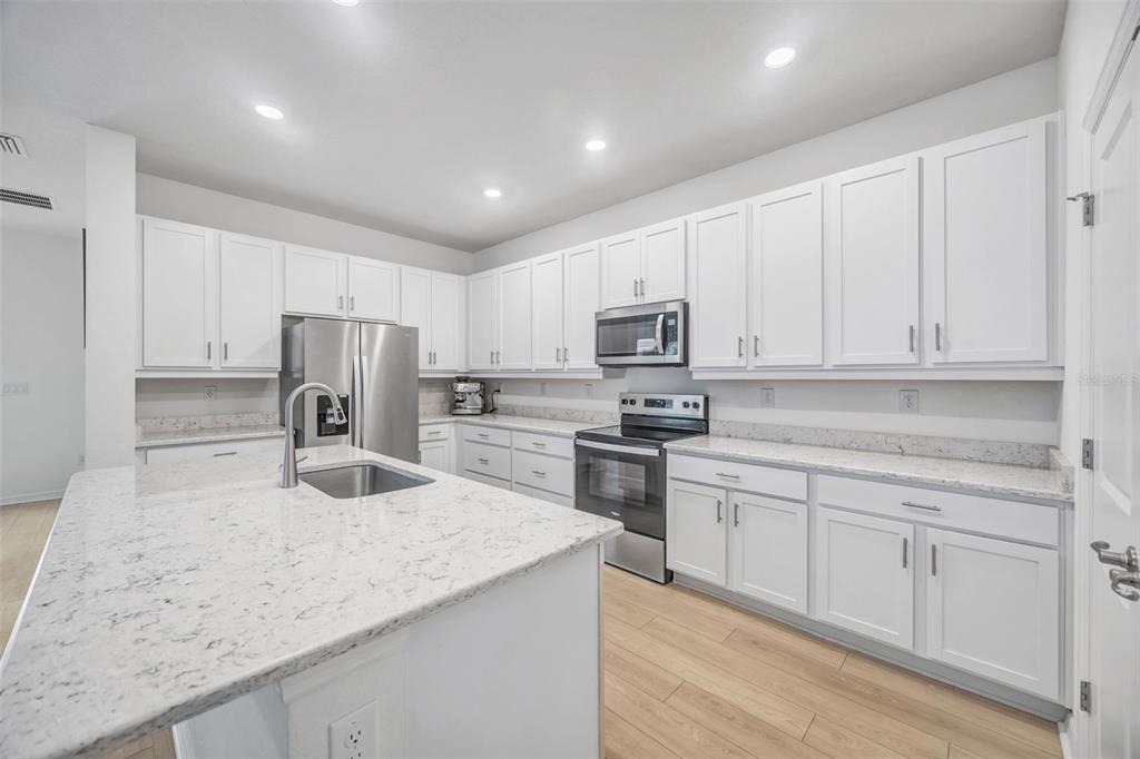 7882 Lennox Loop Wesley Chapel, FL 33544 - Photo 8 of 58 a kitchen with appliances a sink and cabinets