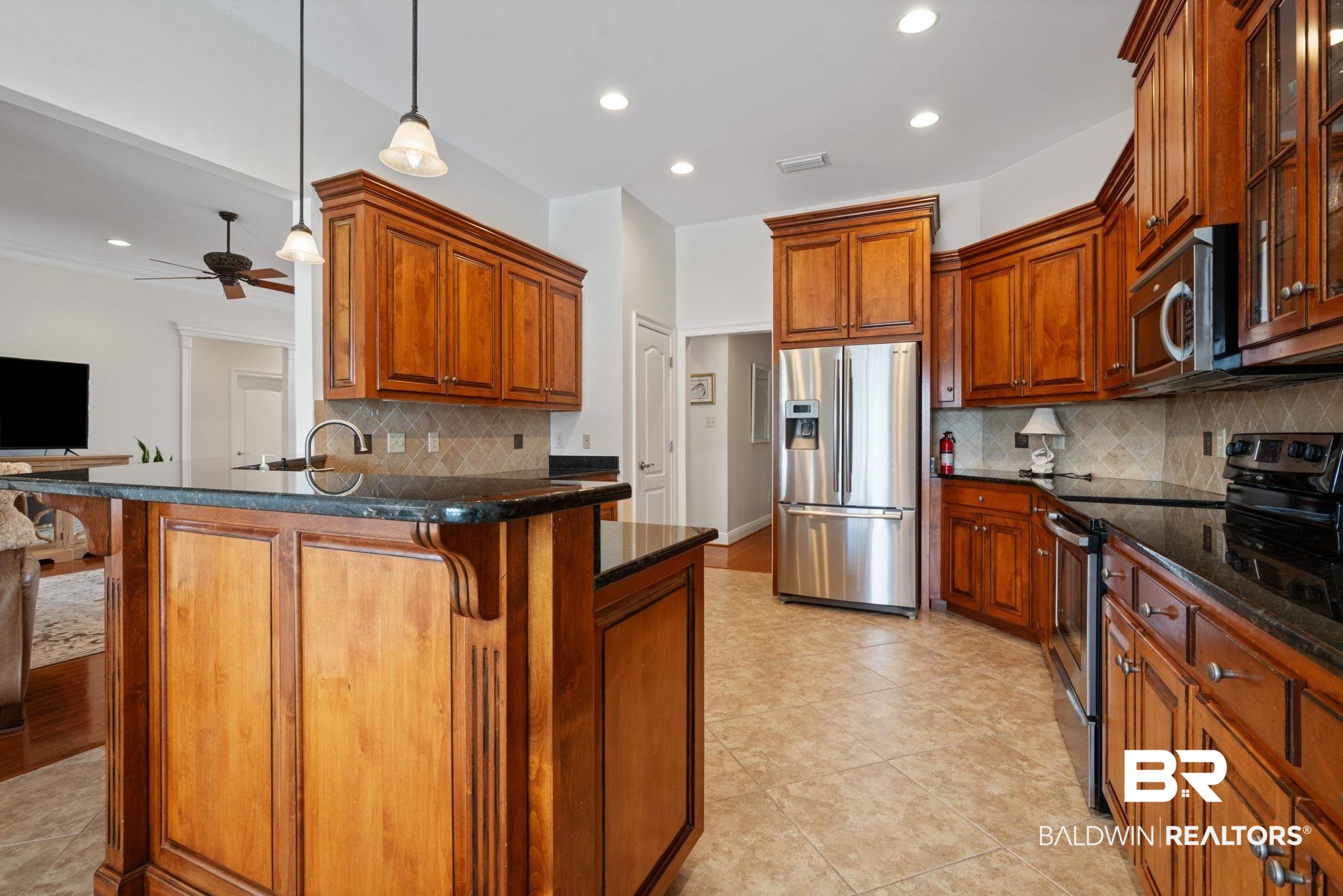 4771 Pecan Ridge East Mobile, AL 36619 - Photo 22 of 48 Kitchen featuring brown cabinets, stainless steel appliances, a kitchen bar, and recessed lighting