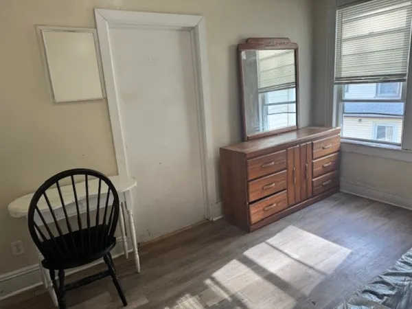 a room with furniture a window and a dresser