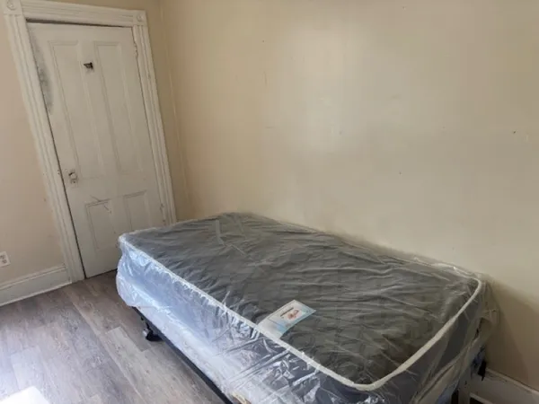 a bed sitting in a bedroom next to a window
