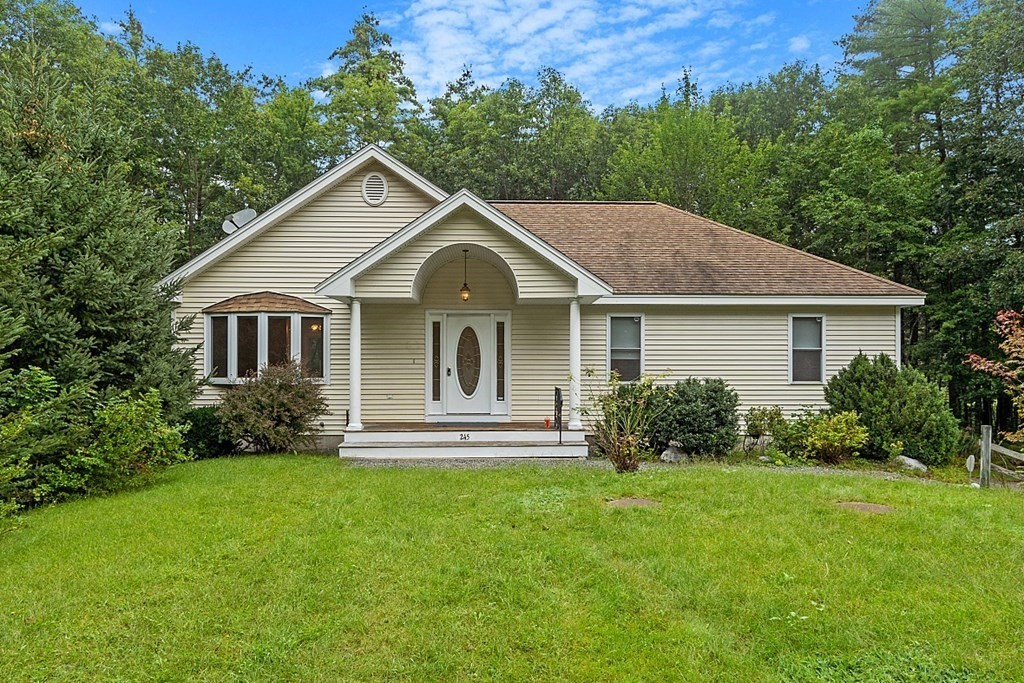 a front view of a house with a yard and garden