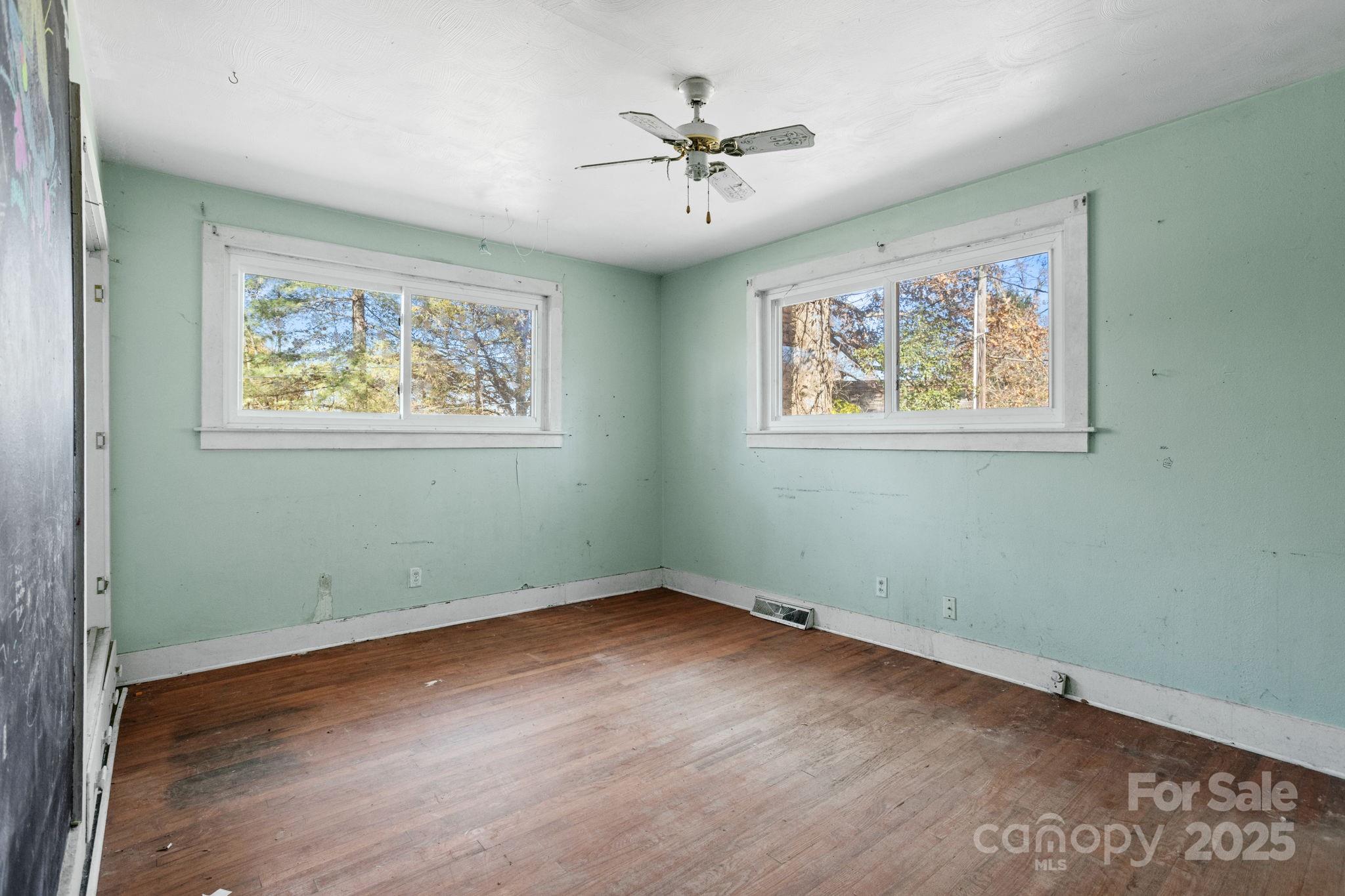 601 East Blue Ridge Road East Flat Rock, NC 28726 - Photo 15 of 48 an empty room with wooden floor and windows