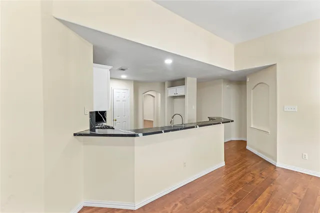 a large white kitchen with sink and refrigerator