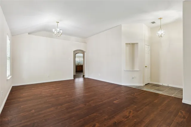an empty room with wooden floor and mirror