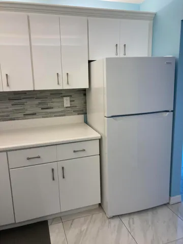 a white refrigerator freezer sitting in a kitchen