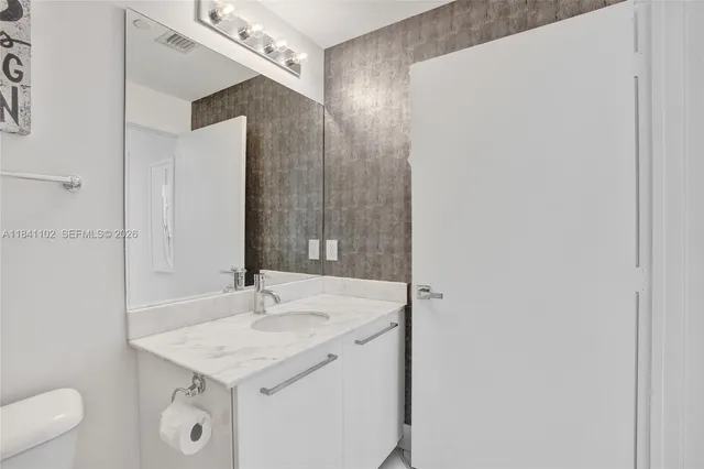 a bathroom with a granite countertop sink and a mirror