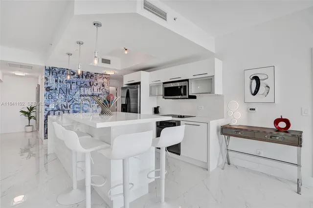 a kitchen with stainless steel appliances kitchen island granite countertop a stove a sink and a refrigerator