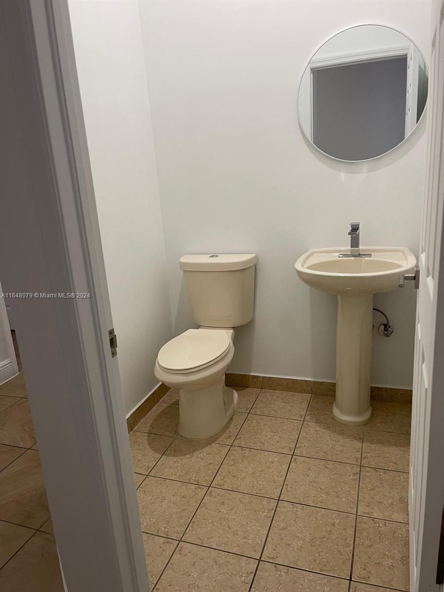 32050 Southwest 204th Avenue Homestead, FL 33030 - Photo 13 of 36 a bathroom with a sink toilet and a mirror