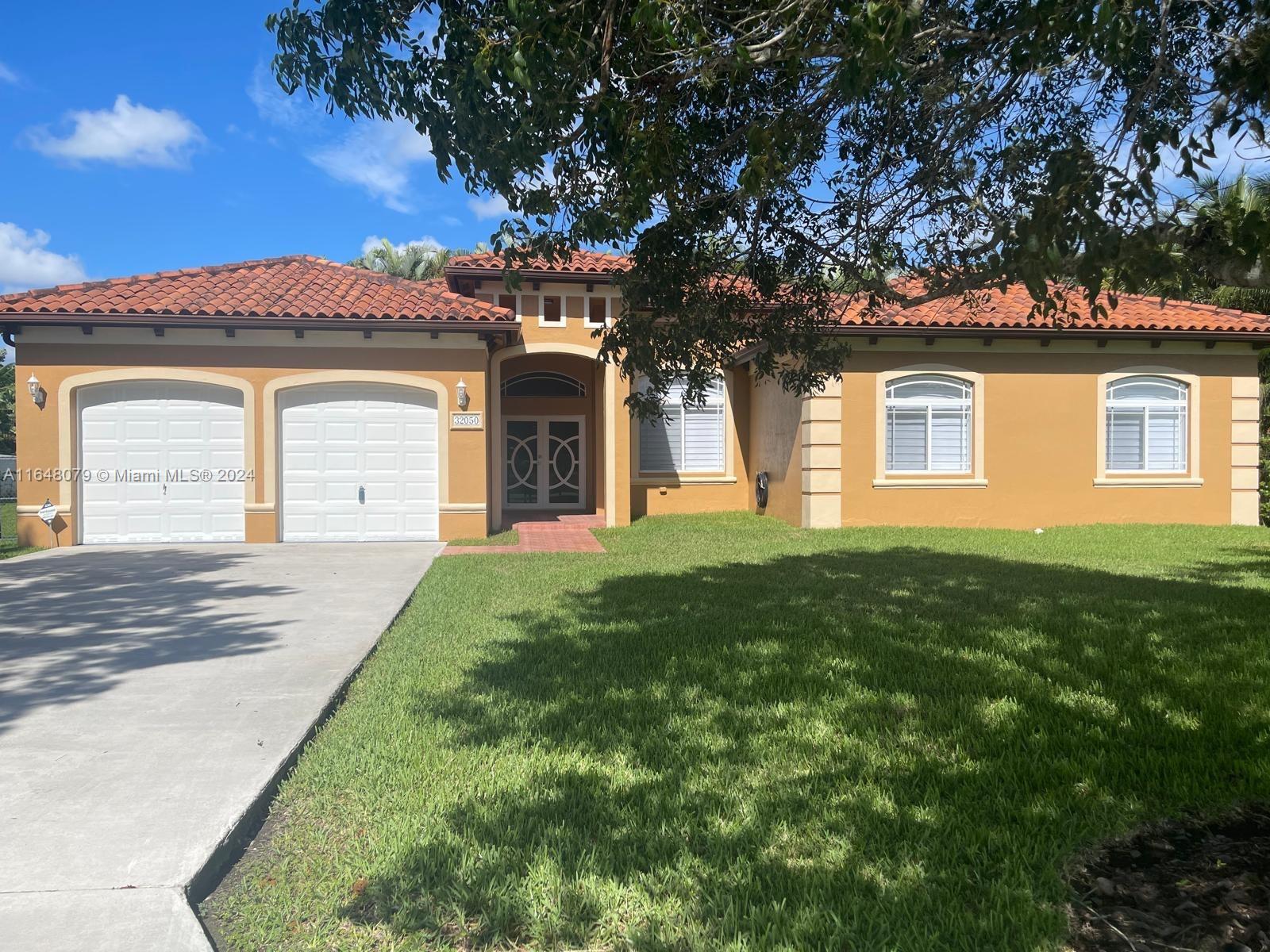 32050 Southwest 204th Avenue Homestead, FL 33030 - Photo 3 of 36 front view of a house with a yard