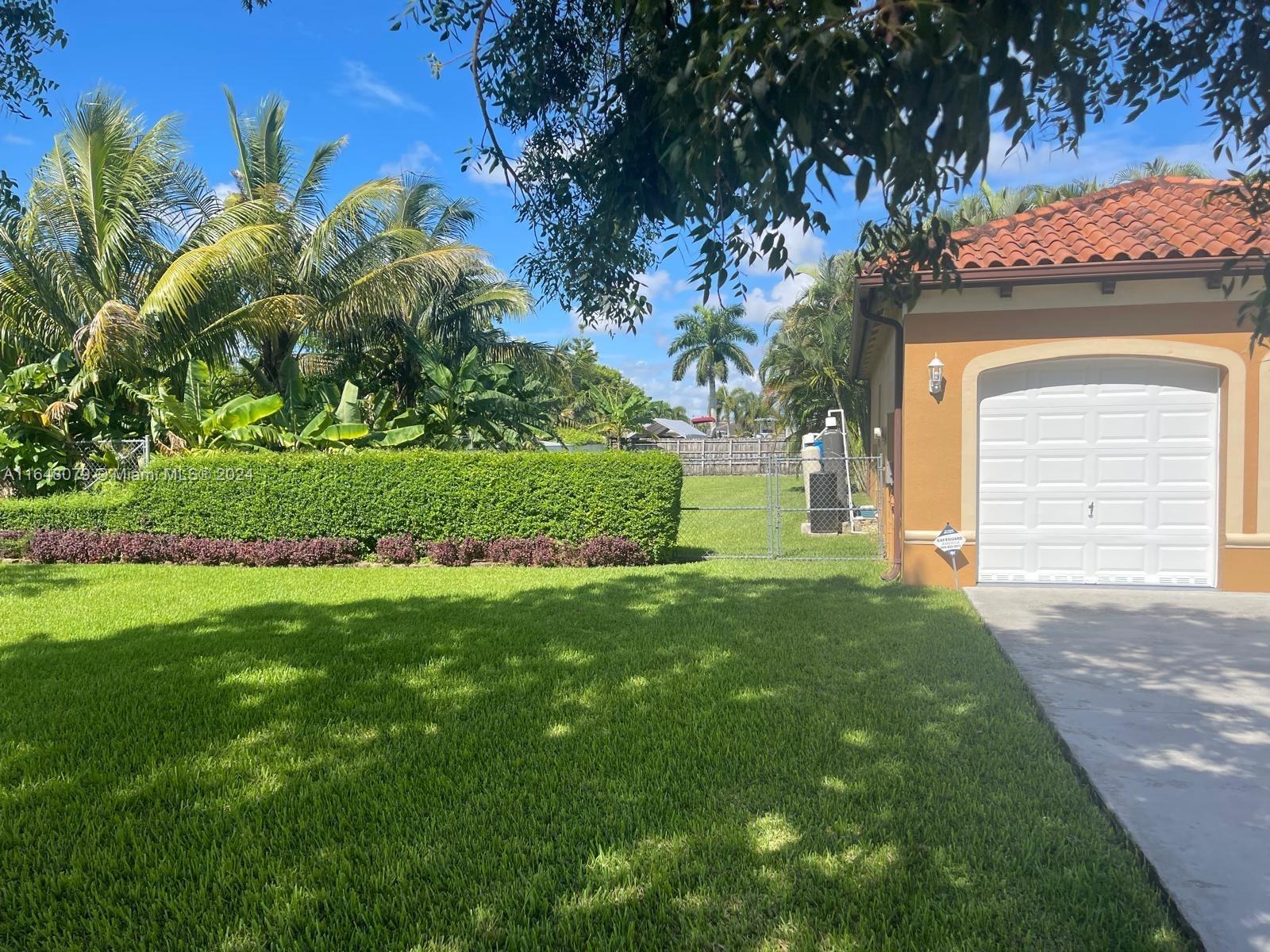 32050 Southwest 204th Avenue Homestead, FL 33030 - Photo 4 of 36 a view of a house with a garden