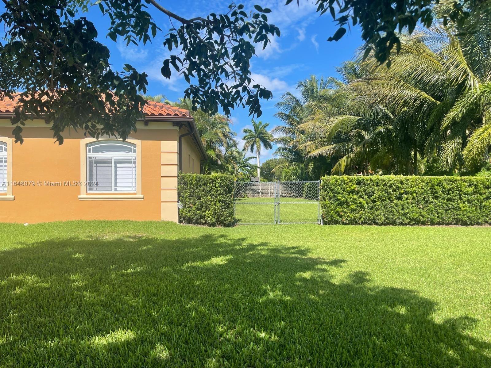 32050 Southwest 204th Avenue Homestead, FL 33030 - Photo 5 of 36 a view of a backyard with plants and large trees