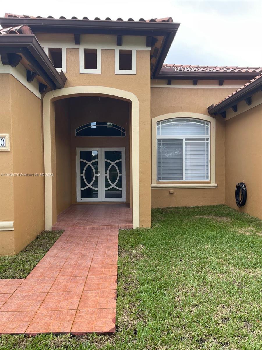 32050 Southwest 204th Avenue Homestead, FL 33030 - Photo 6 of 36 a front view of a house with garden