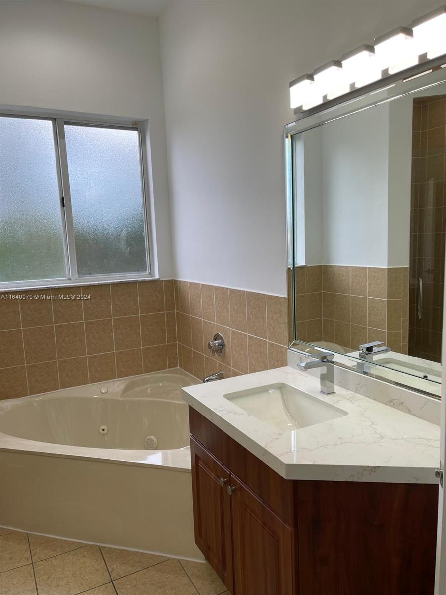 32050 Southwest 204th Avenue Homestead, FL 33030 - Photo 10 of 36 a bathroom with a sink and a mirror