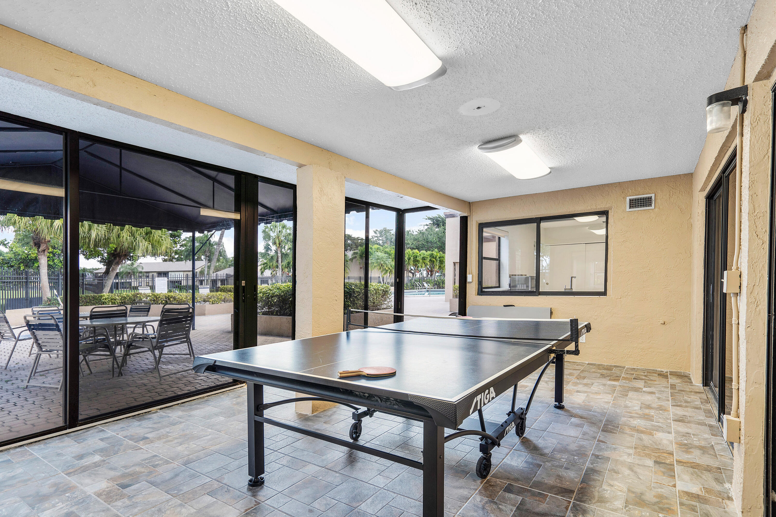 8458 Boca Glades Boulevard East Boca Raton, FL 33434 - Photo 22 of 28 a living room with pool table and a floor to ceiling window