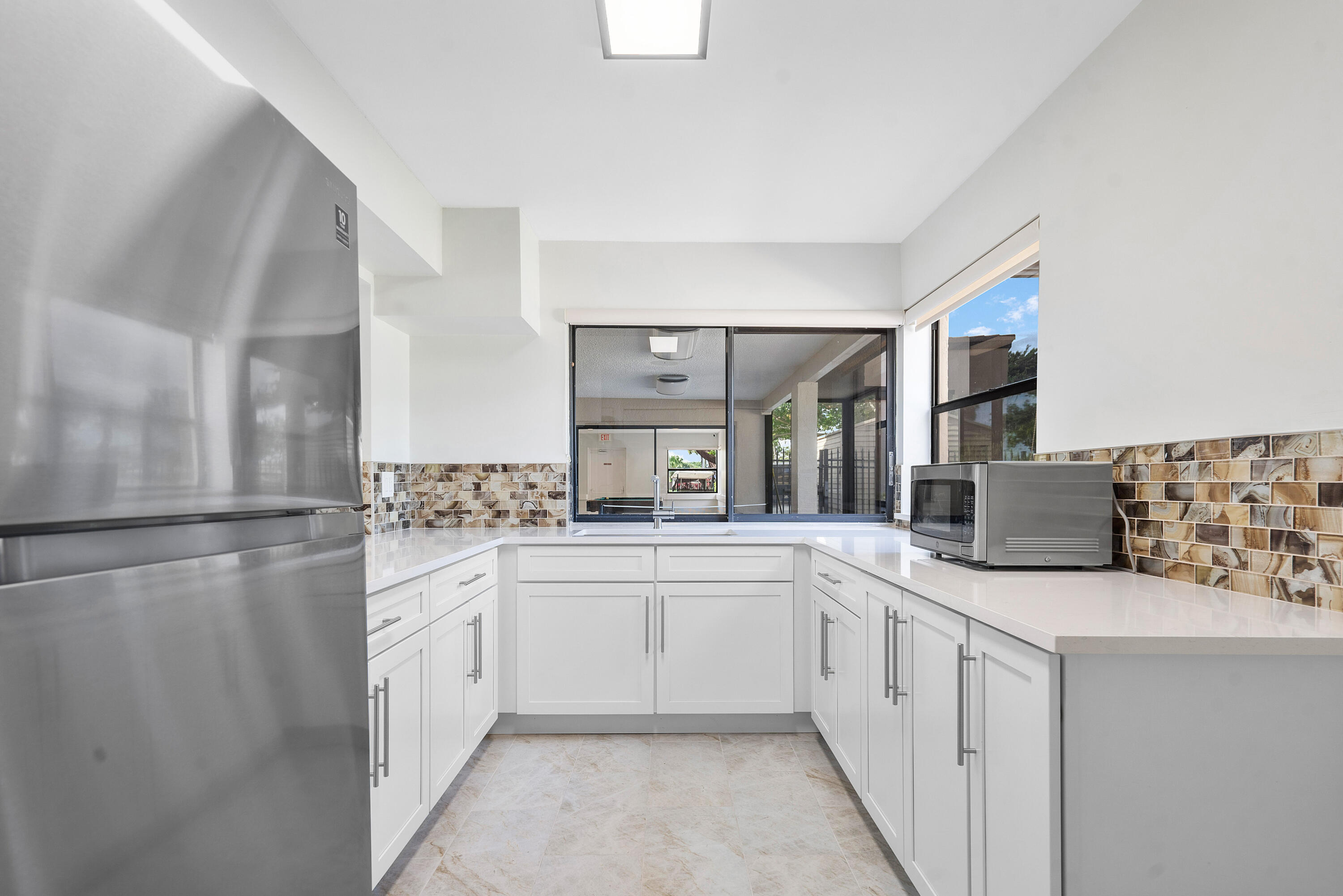 8458 Boca Glades Boulevard East Boca Raton, FL 33434 - Photo 23 of 28 a kitchen with stainless steel appliances a sink and refrigerator