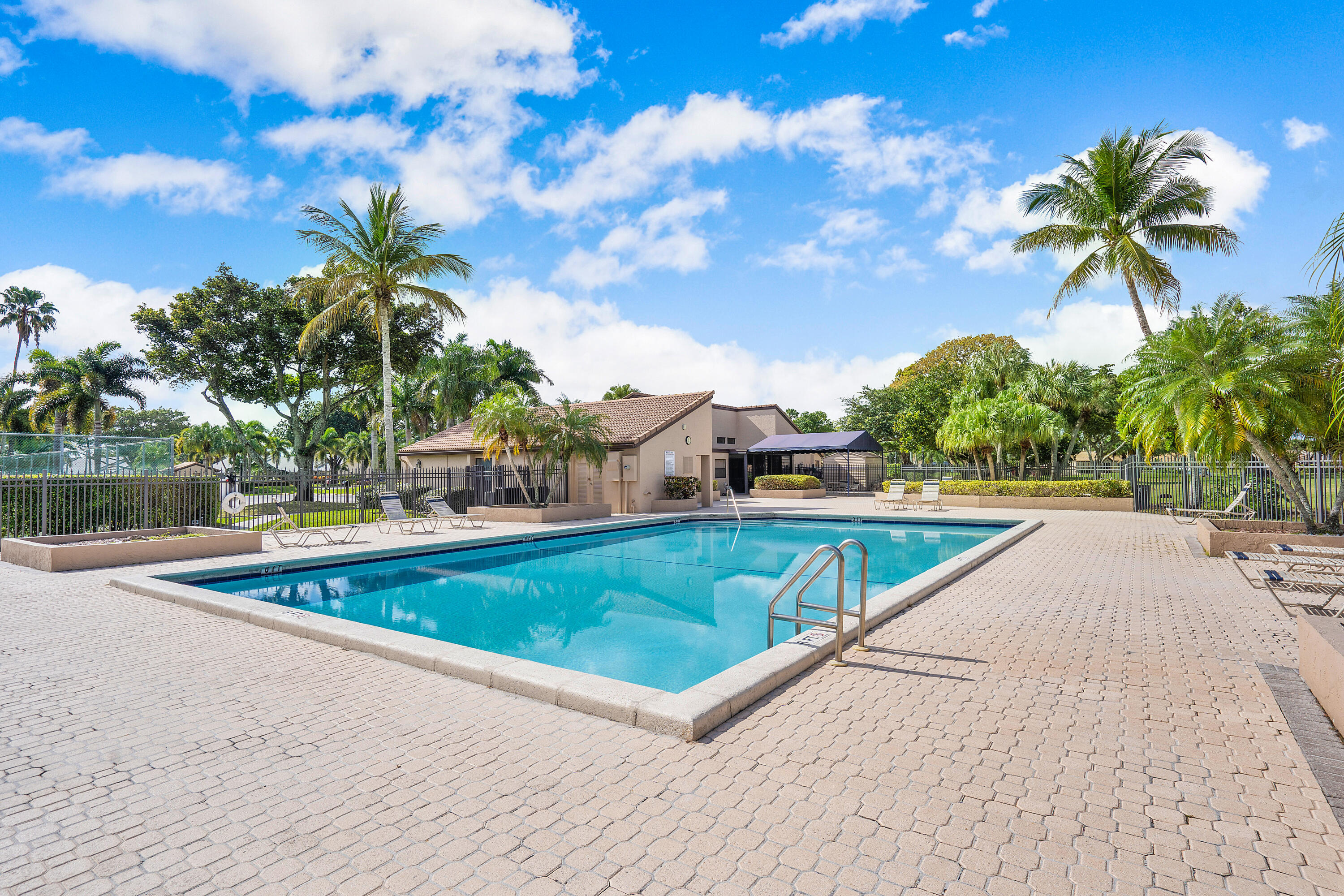8458 Boca Glades Boulevard East Boca Raton, FL 33434 - Photo 25 of 28 a view of a swimming pool with a yard and palm trees