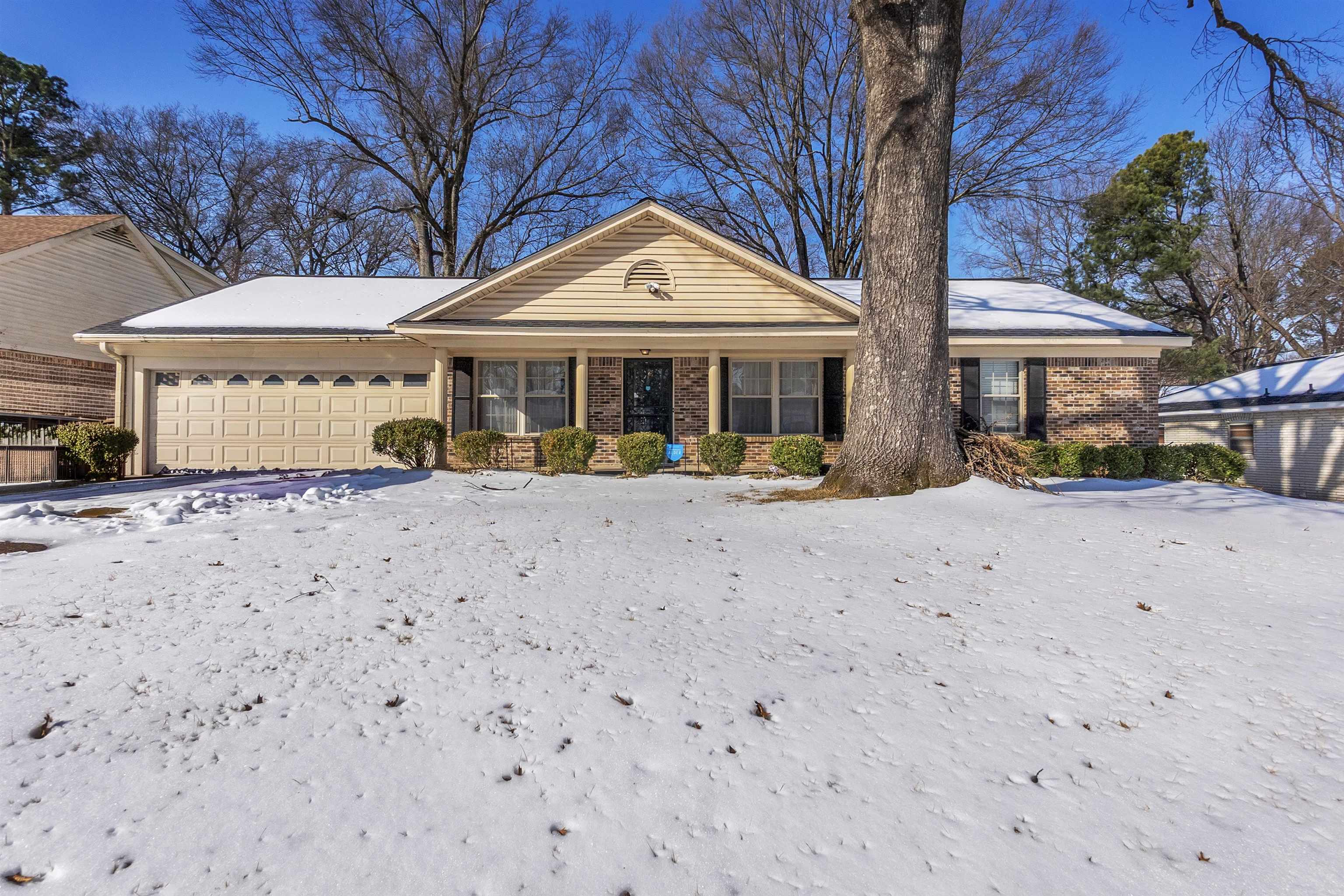 Ranch-style home with covered porch, brick siding, and an attached garage
