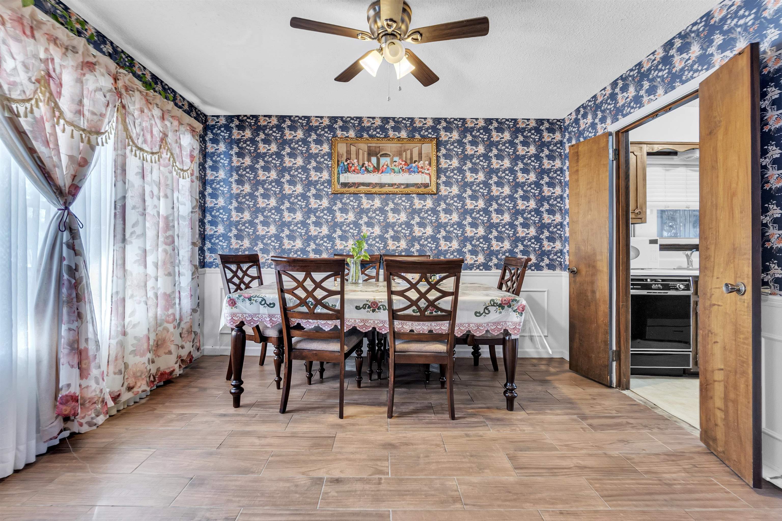 3463 Dupre Street Memphis, TN 38115 - Photo 7 of 25 Dining room with wainscoting, wallpapered walls, wood finish floors, plenty of natural light, and ceiling fan