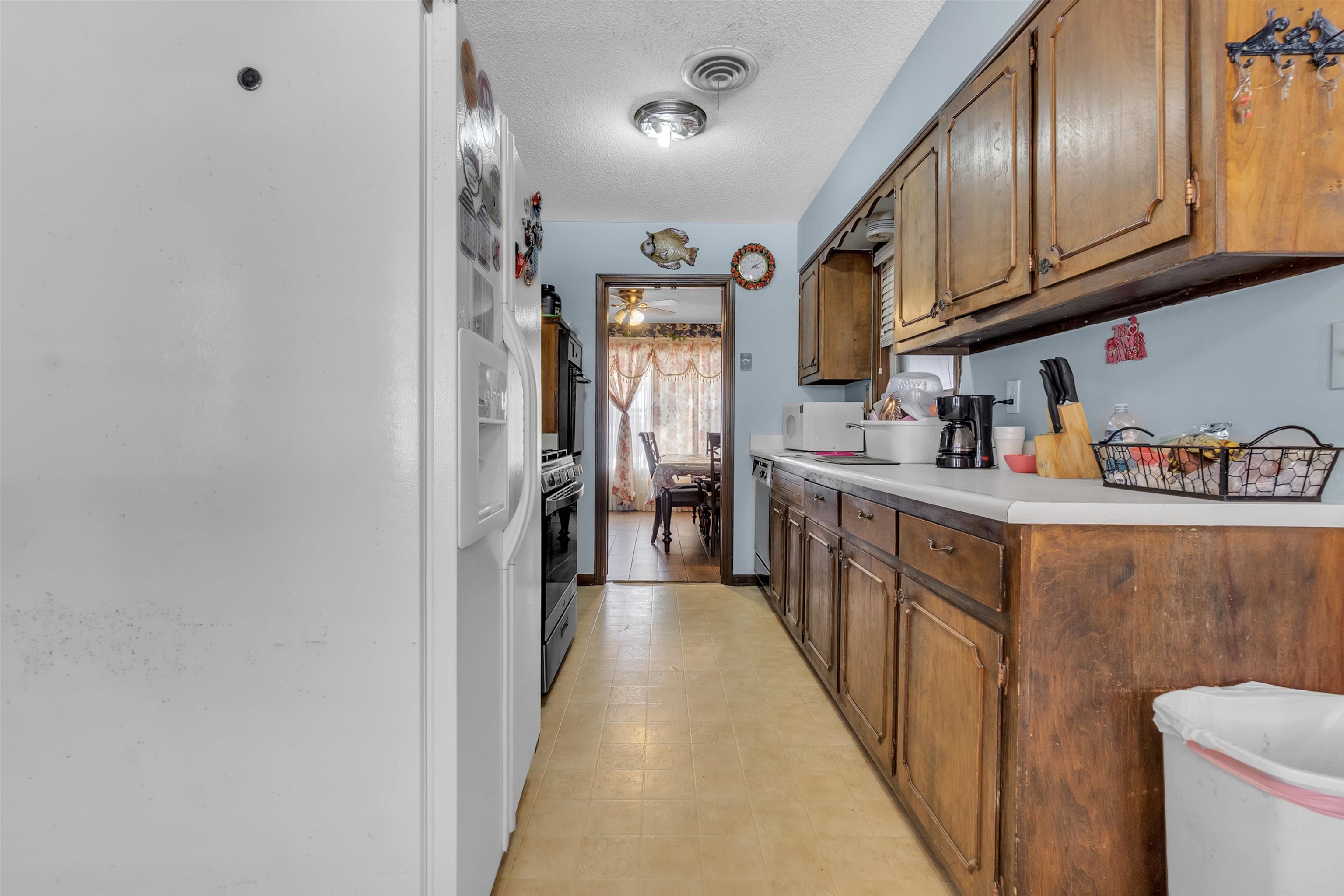 3463 Dupre Street Memphis, TN 38115 - Photo 10 of 25 Kitchen featuring light countertops, white appliances, a textured ceiling, light flooring, and ceiling fan
