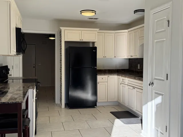 a kitchen with stainless steel appliances granite countertop a refrigerator and a stove