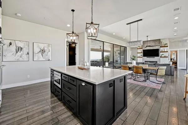 a kitchen with stainless steel appliances granite countertop a kitchen island a stove and a wooden floor