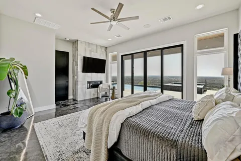 a bedroom with a bed flat screen tv and a large window