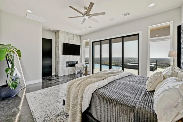 a bedroom with a bed flat screen tv and a large window