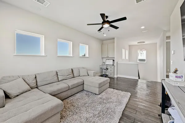 a living room with furniture and a wooden floor