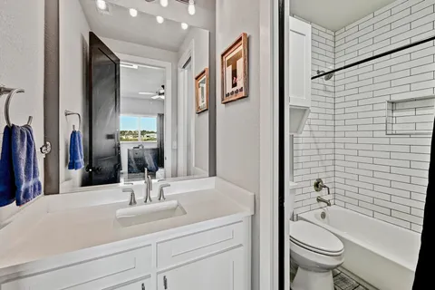 a bathroom with a granite countertop sink toilet and shower