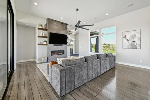 a living room with furniture a flat screen tv and a fireplace