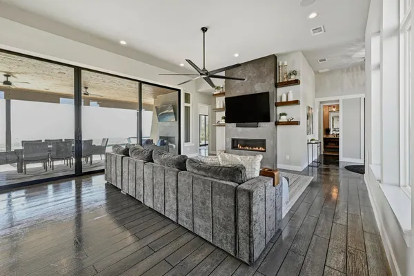 a living room with furniture a flat screen tv and a floor to ceiling window