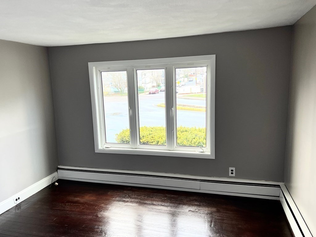 150 Locust Street, Unit 1 Winthrop, MA 02152 - Photo 9 of 11 a view of an empty room with wooden floor and a window