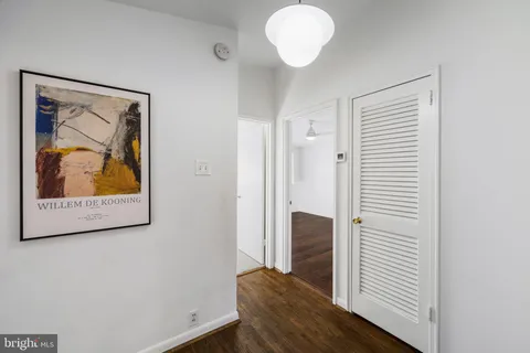 a view of a hallway with wooden floor and closet