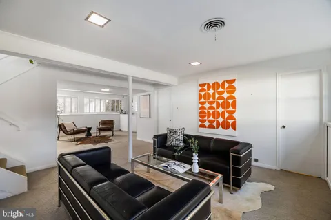 a living room with furniture a flat screen tv and a window