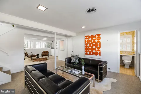 a living room with furniture a flat screen tv and a window