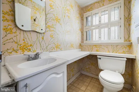 a bathroom with a toilet sink and mirror