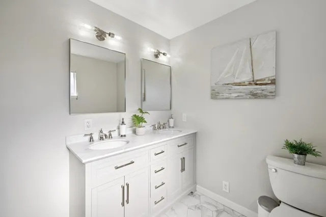 a bathroom with a sink mirror vanity and toilet
