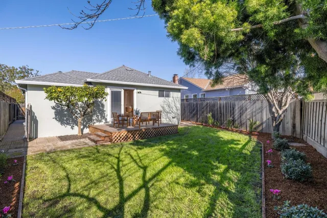 a view of a house with backyard and sitting area