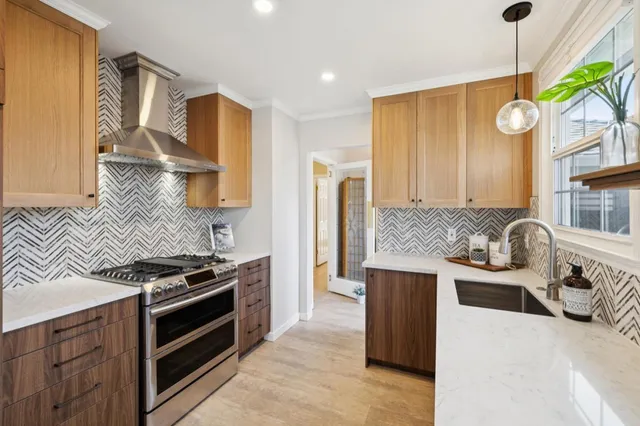 a kitchen with stainless steel appliances granite countertop a sink stove and refrigerator