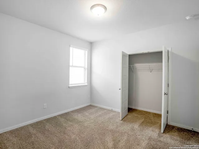 an empty room with windows and closet