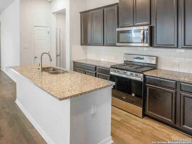 a kitchen with stainless steel appliances granite countertop a stove microwave and sink
