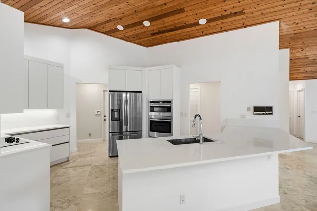 a kitchen with stainless steel appliances a sink and a refrigerator